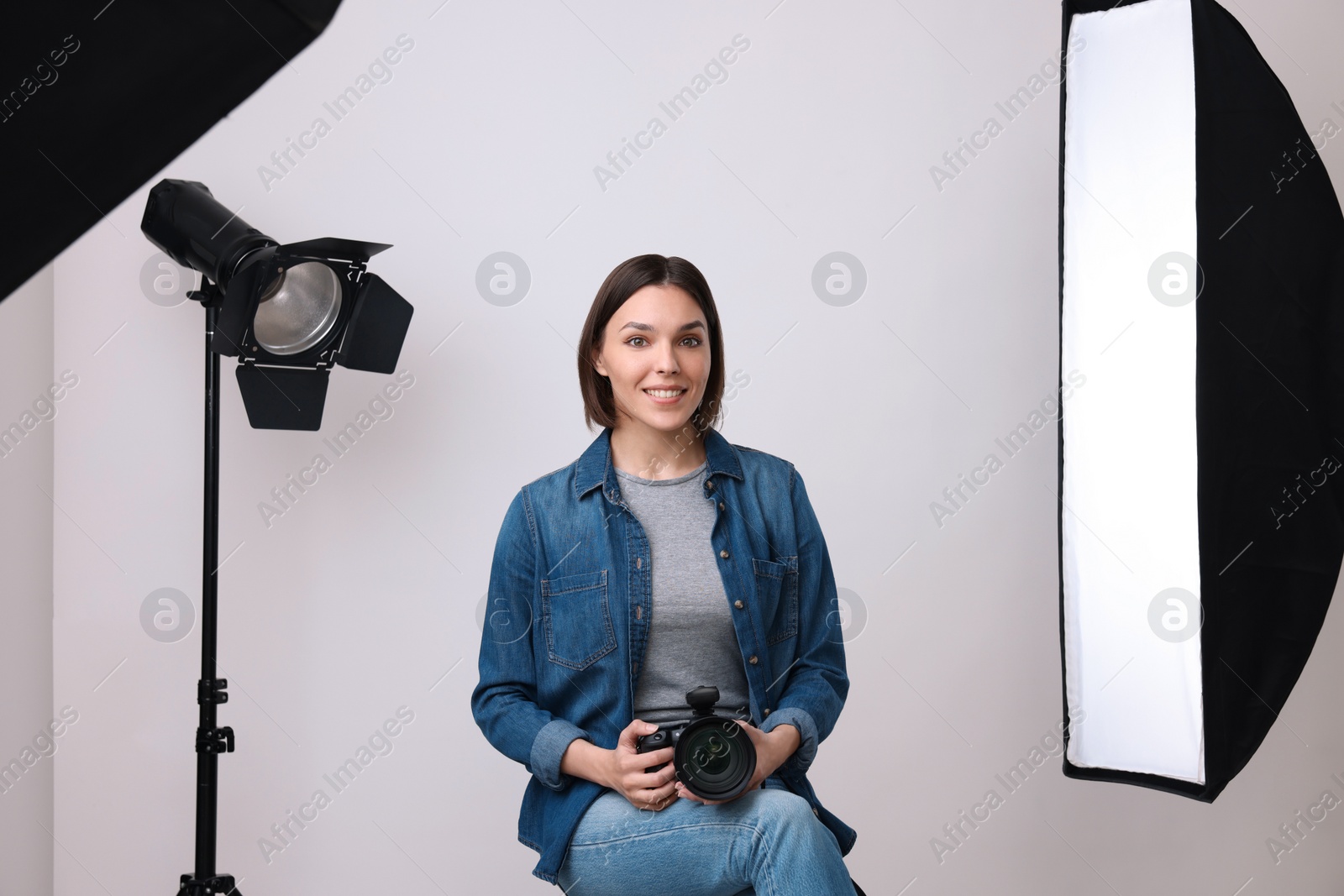 Photo of Professional photographer with camera in modern photo studio