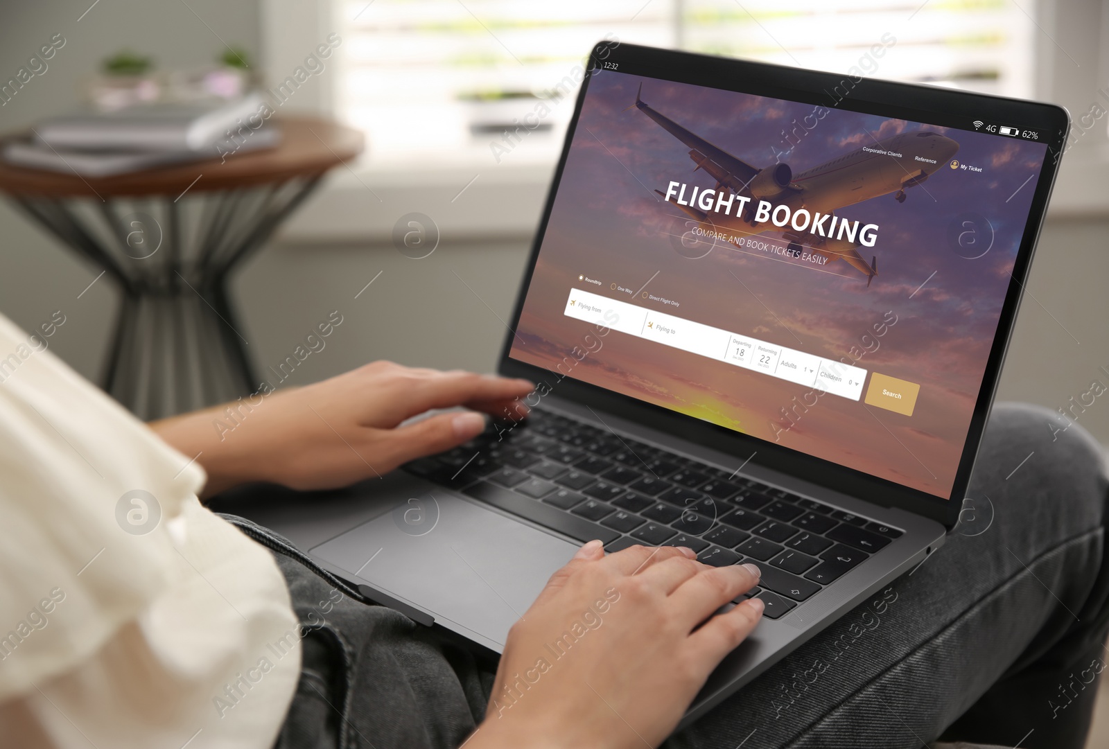 Image of Woman using laptop to book flight at home, closeup