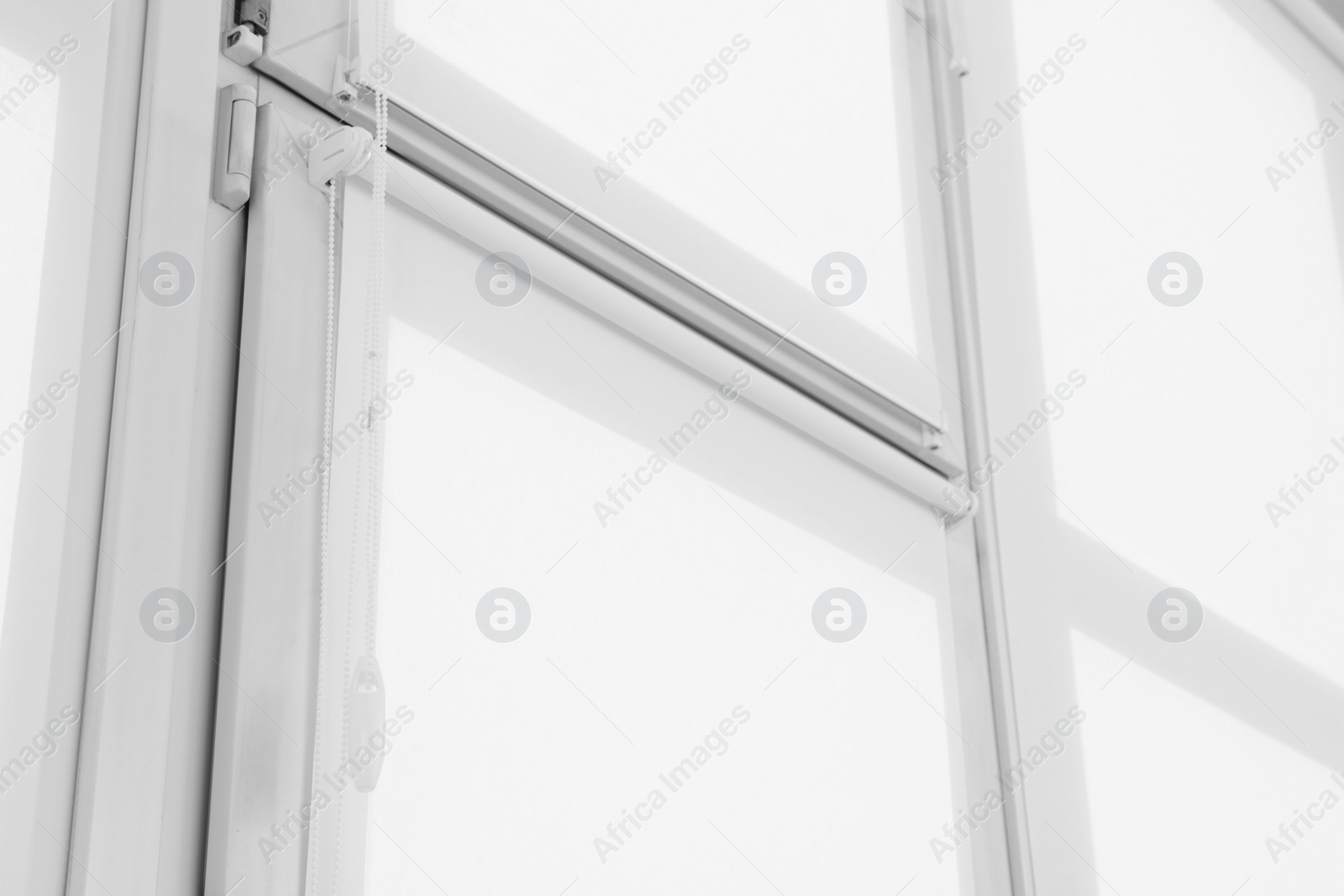 Photo of Window with closed white roller blinds indoors