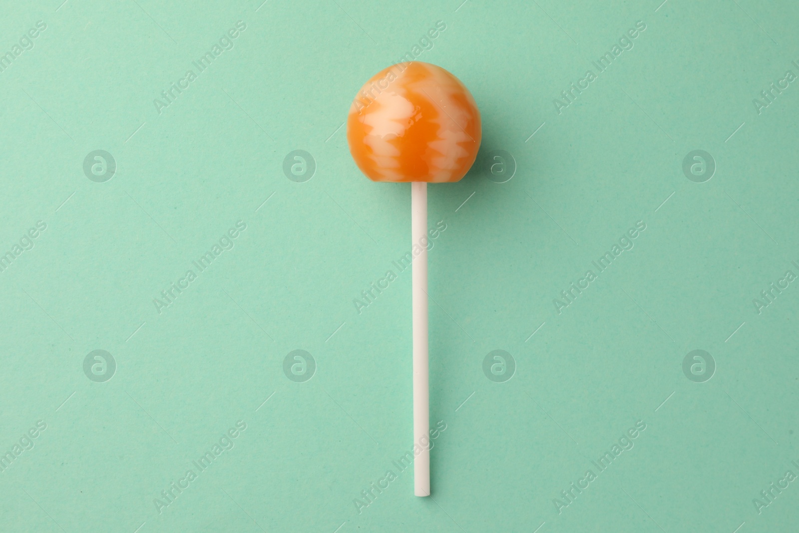 Photo of Tasty lollipop on turquoise background, top view