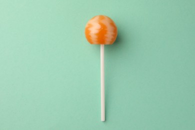 Photo of Tasty lollipop on turquoise background, top view