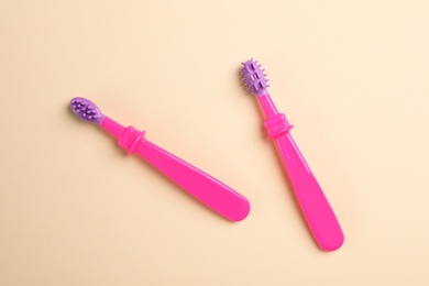 Manual toothbrushes for children on color background, top view