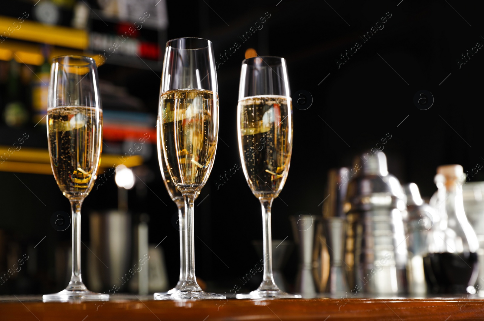 Photo of Glasses of champagne on counter in bar. Space for text