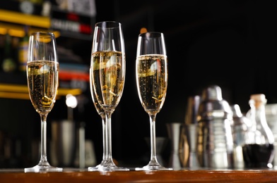 Photo of Glasses of champagne on counter in bar. Space for text