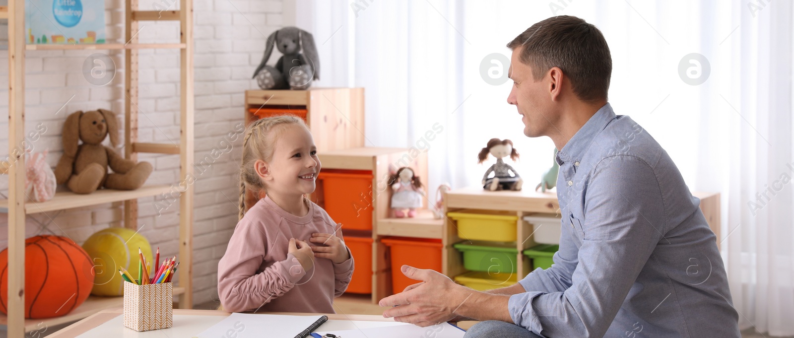 Image of Child psychotherapist working with little girl in office