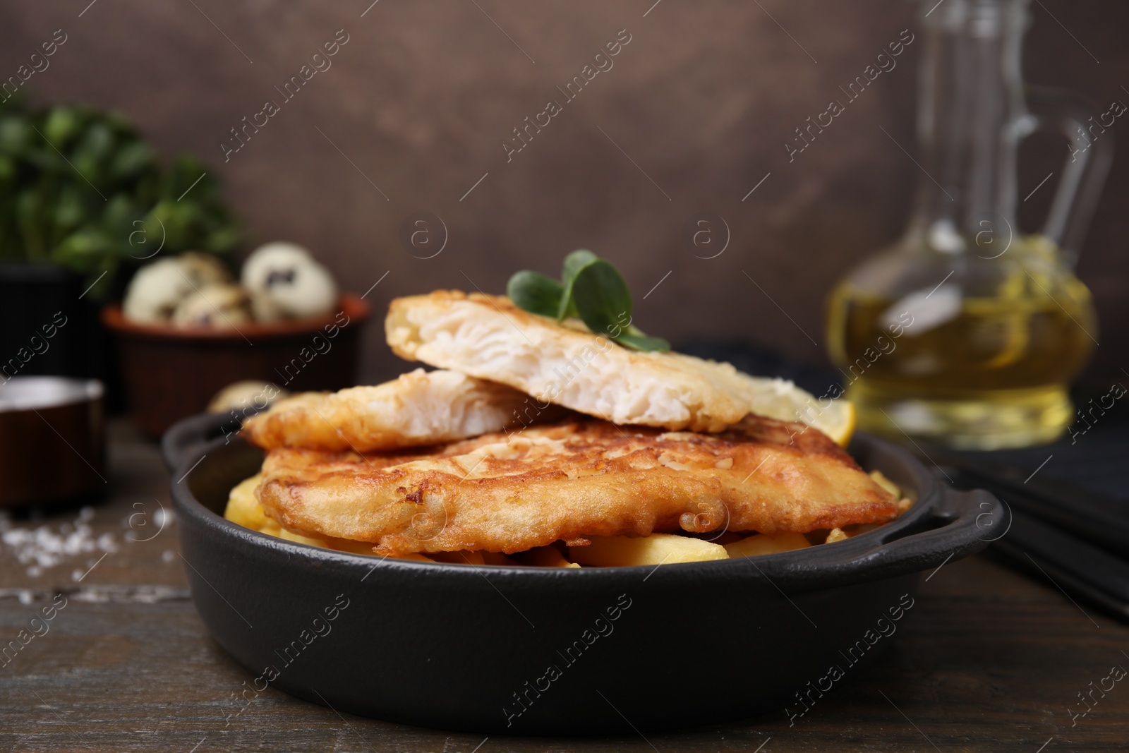 Photo of Tasty soda water battered fish and potato chips on wooden table