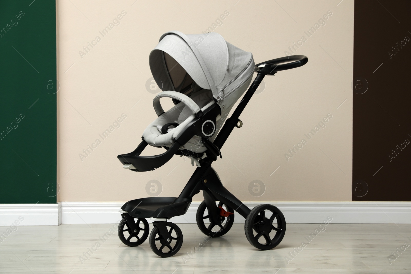 Photo of Baby carriage. Modern pram near beige wall