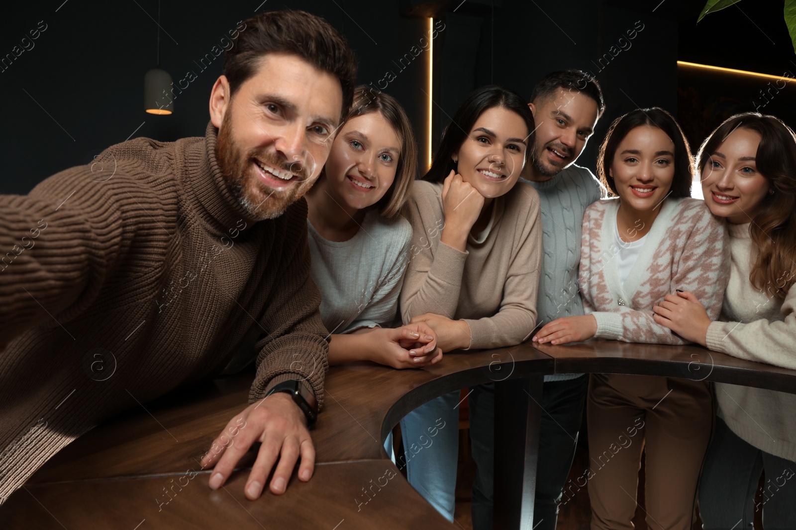 Photo of Group of friends taking selfie together in cafe