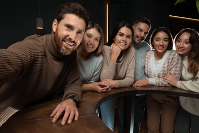 Photo of Group of friends taking selfie together in cafe