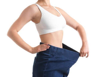 Photo of Young slim woman wearing oversized jeans on white background, closeup