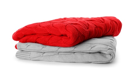 Photo of Stack of different warm sweaters isolated on white