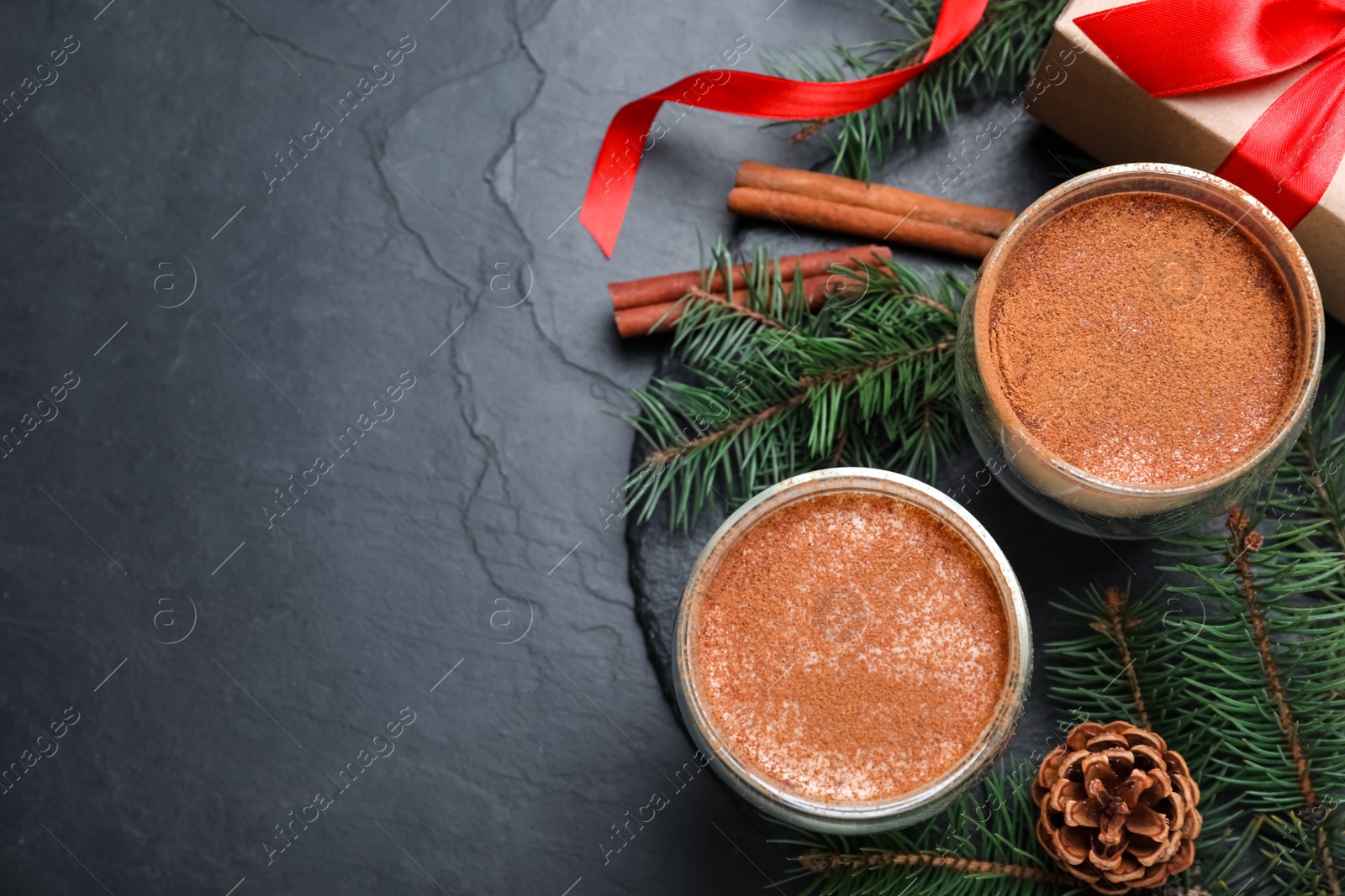 Photo of Delicious Christmas cocktail with liqueur on black table, flat lay. Space for text