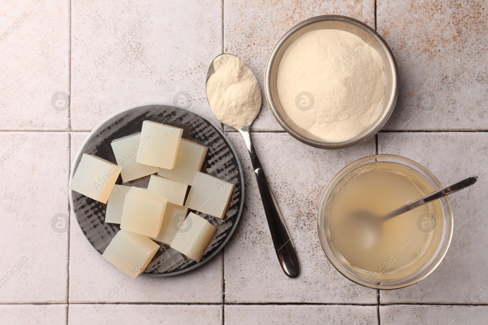 Photo of Agar-agar jelly and powder on tiled surface, flat lay