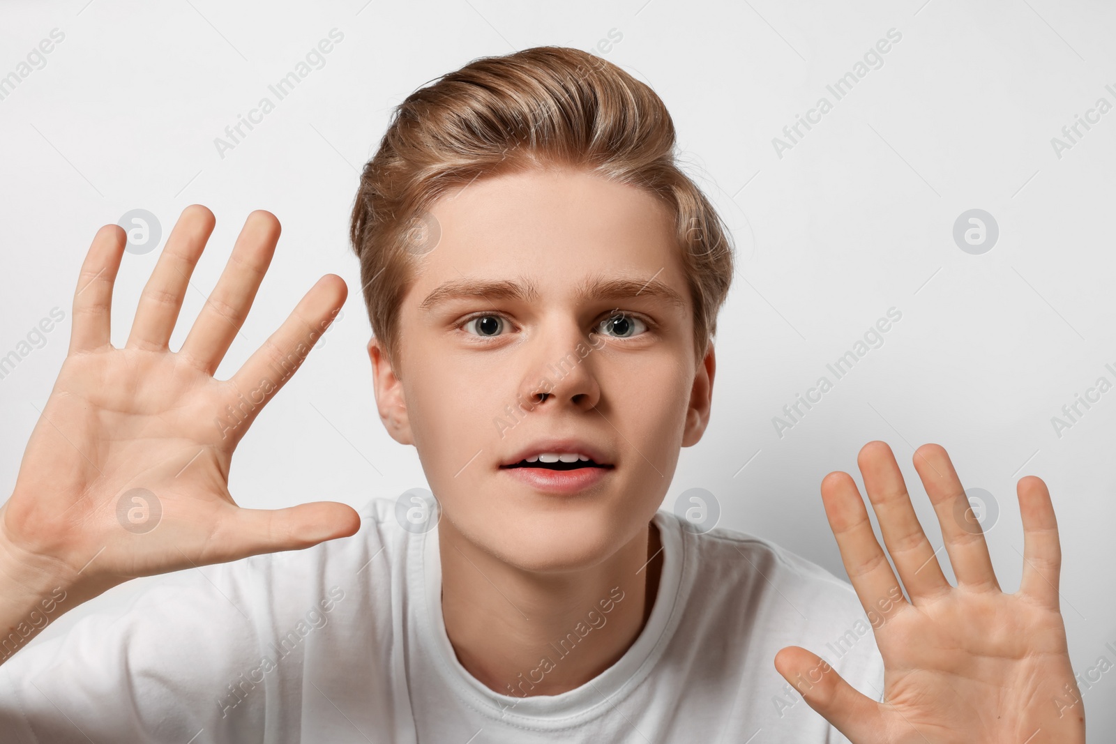 Photo of Excited teenage boy stuck to transparent screen