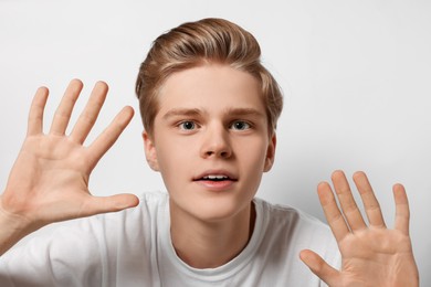 Excited teenage boy stuck to transparent screen