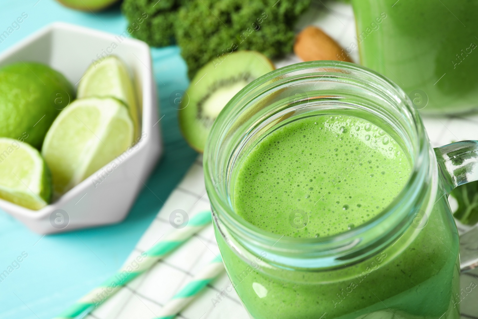 Photo of Tasty fresh kale smoothie on light blue table, closeup