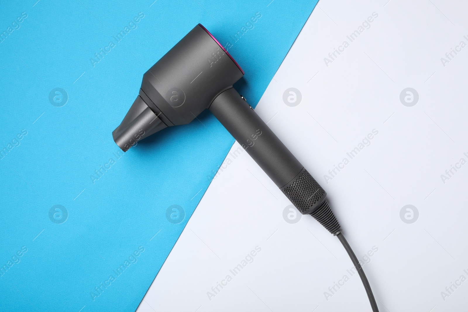 Photo of Hair dryer on color background, top view. Professional hairdresser tool