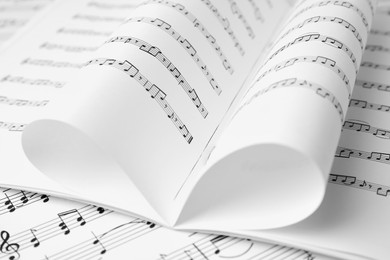 Photo of Sheets of paper with music notes as background, closeup