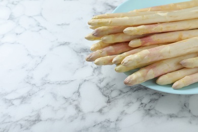 Photo of Fresh white asparagus on marble table, closeup. Space for text