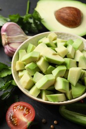 Photo of Fresh ingredients for guacamole on black table, closeup