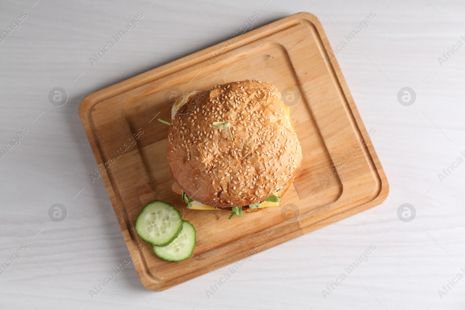 Photo of Board with delicious vegetarian burger on white wooden table, top view