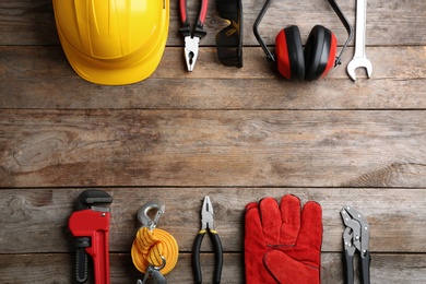 Photo of Flat lay composition with different construction tools and space for text on wooden background