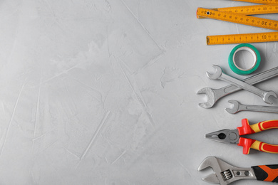 Flat lay composition with construction tools on light grey background. Space for text