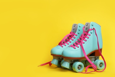 Photo of Pair of stylish quad roller skates on color background. Space for text