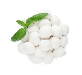 Photo of Pile of mozzarella cheese balls and basil on white background, top view
