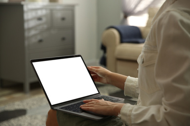 Photo of Woman using laptop at home, closeup. Space for design