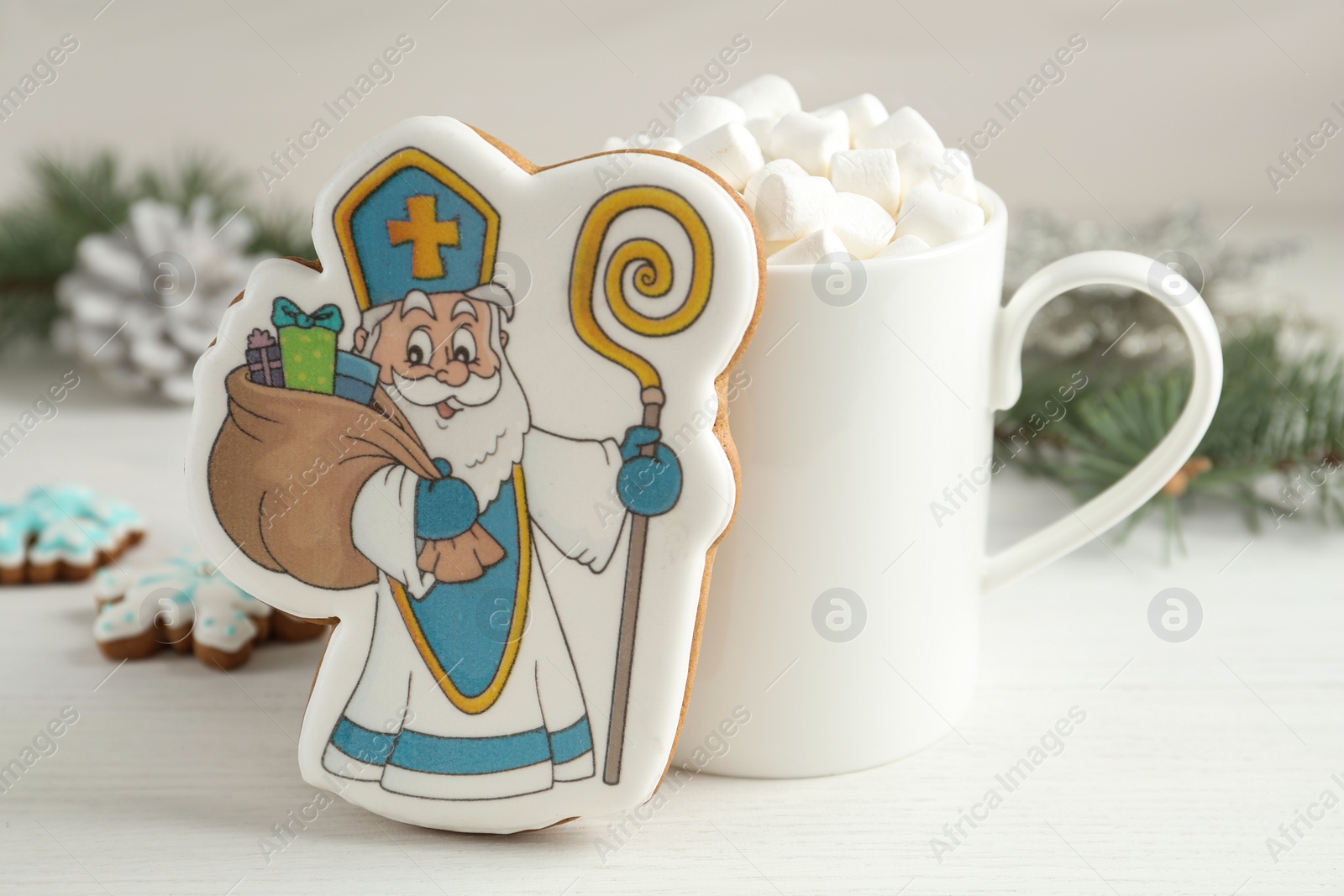 Photo of Delicious gingerbread cookies and hot drink on white wooden table. St. Nicholas Day celebration