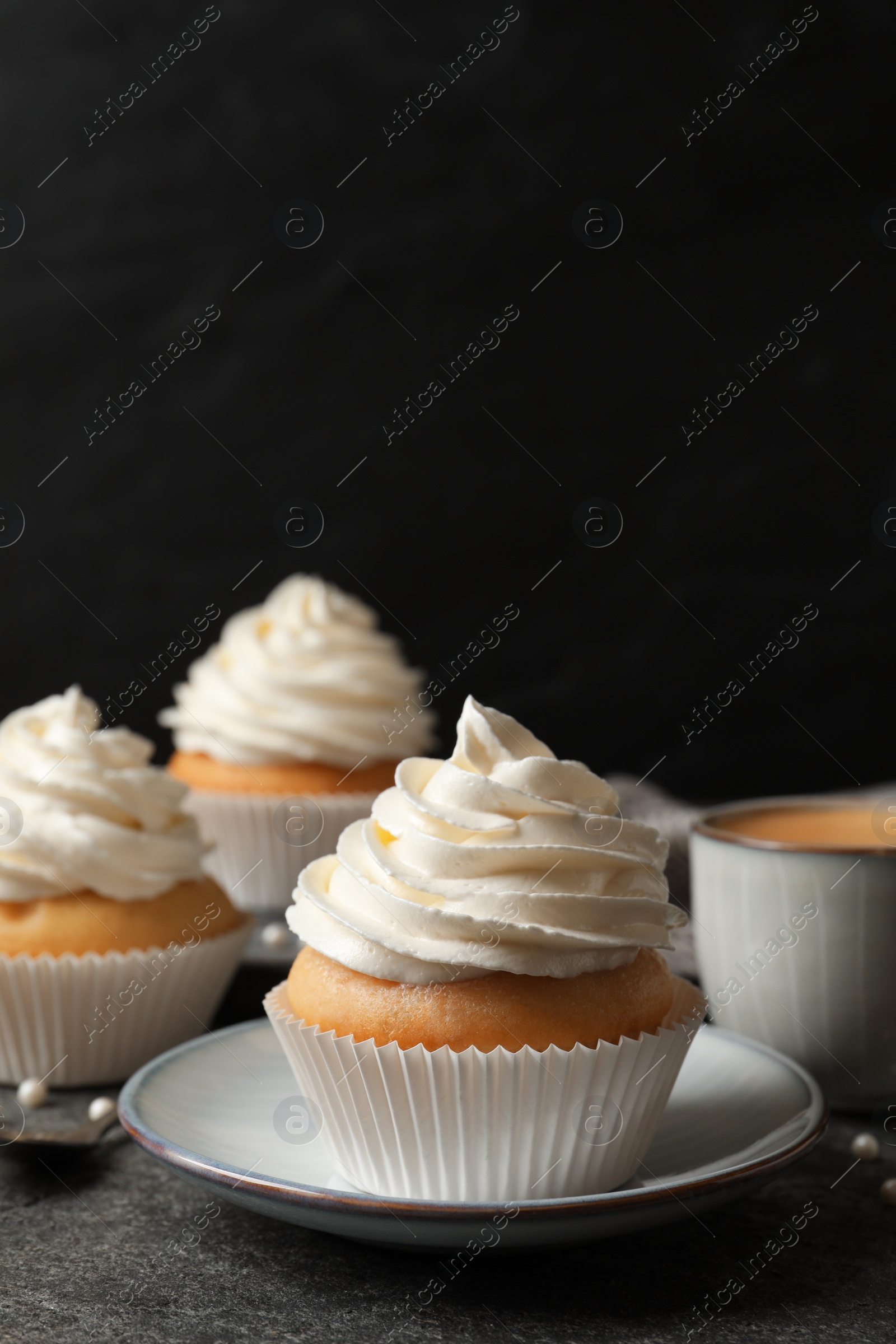 Photo of Delicious cupcakes with cream on grey table. Space for text