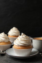 Photo of Delicious cupcakes with cream on grey table. Space for text