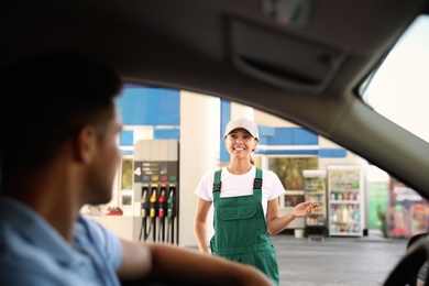 Man in car speaking with gas station worker
