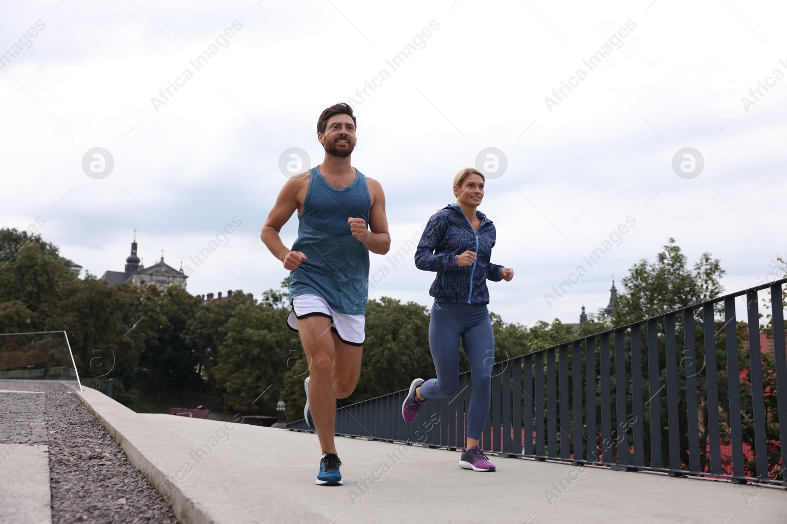 Photo of Healthy lifestyle. Happy sporty couple running outdoors