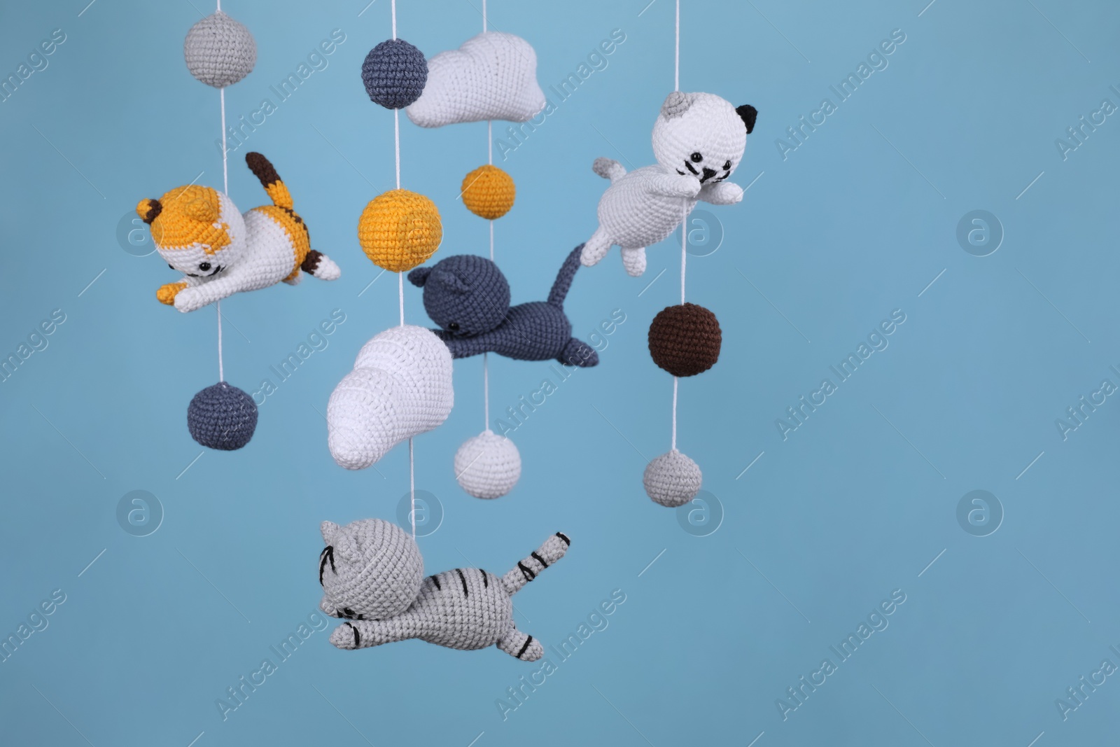 Photo of Cute baby crib mobile on light blue background