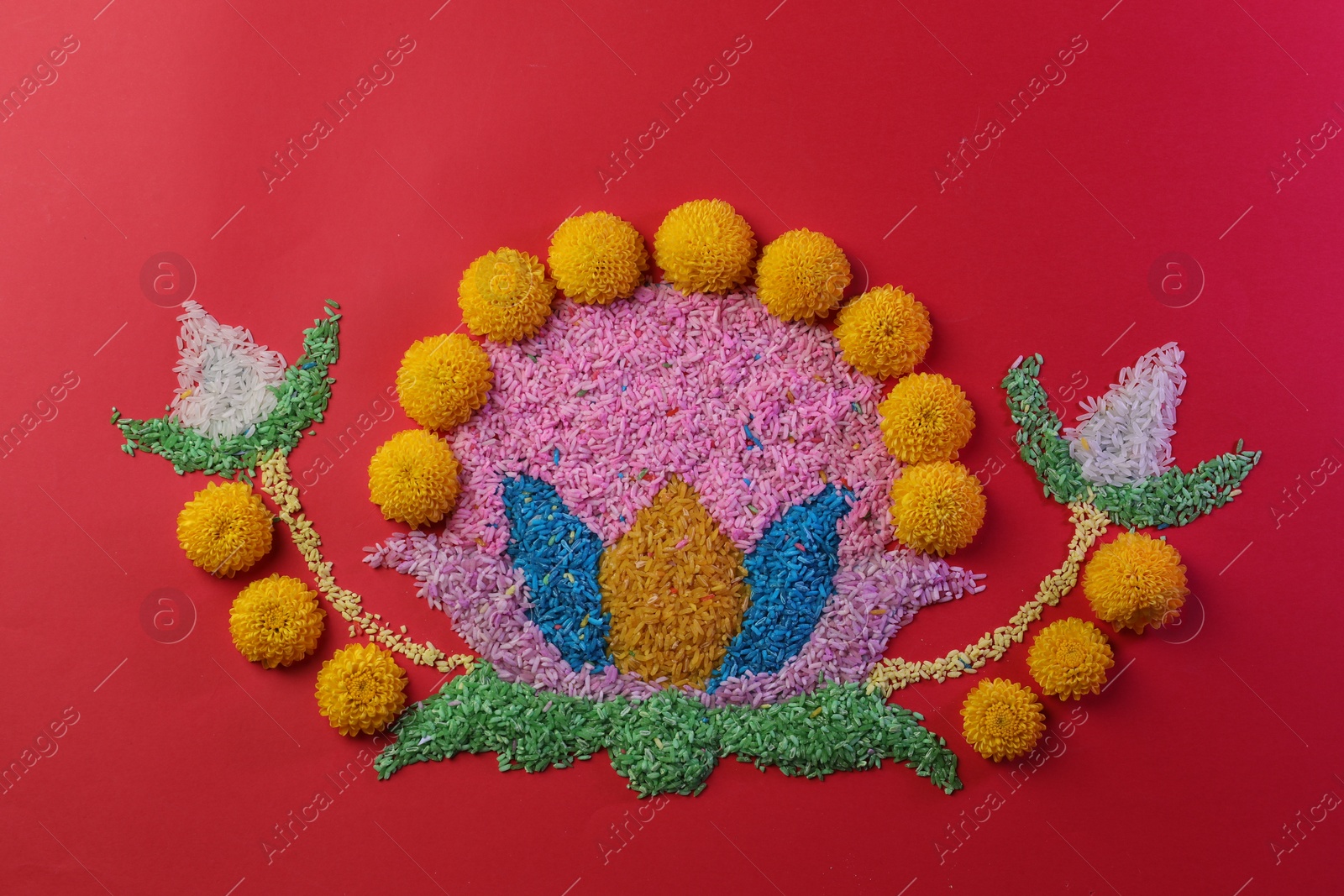 Photo of Happy Diwali. Composition with colorful rangoli and chrysanthemum flowers on red background, top view