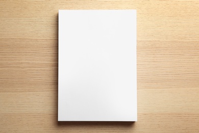 Photo of Stack of blank paper sheets for brochure on wooden background, top view. Mock up