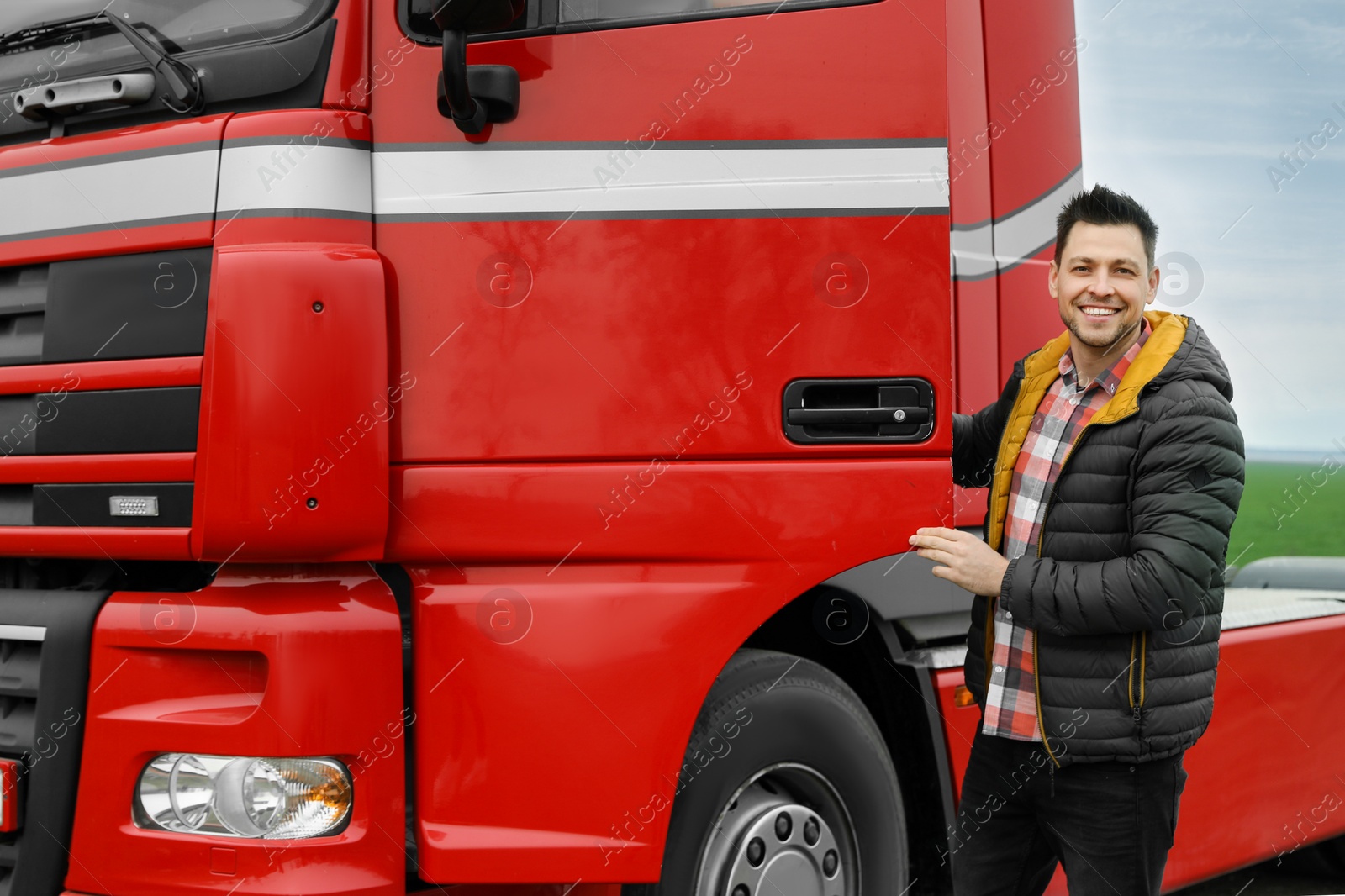 Photo of Portrait of happy driver opening door of modern truck outdoors