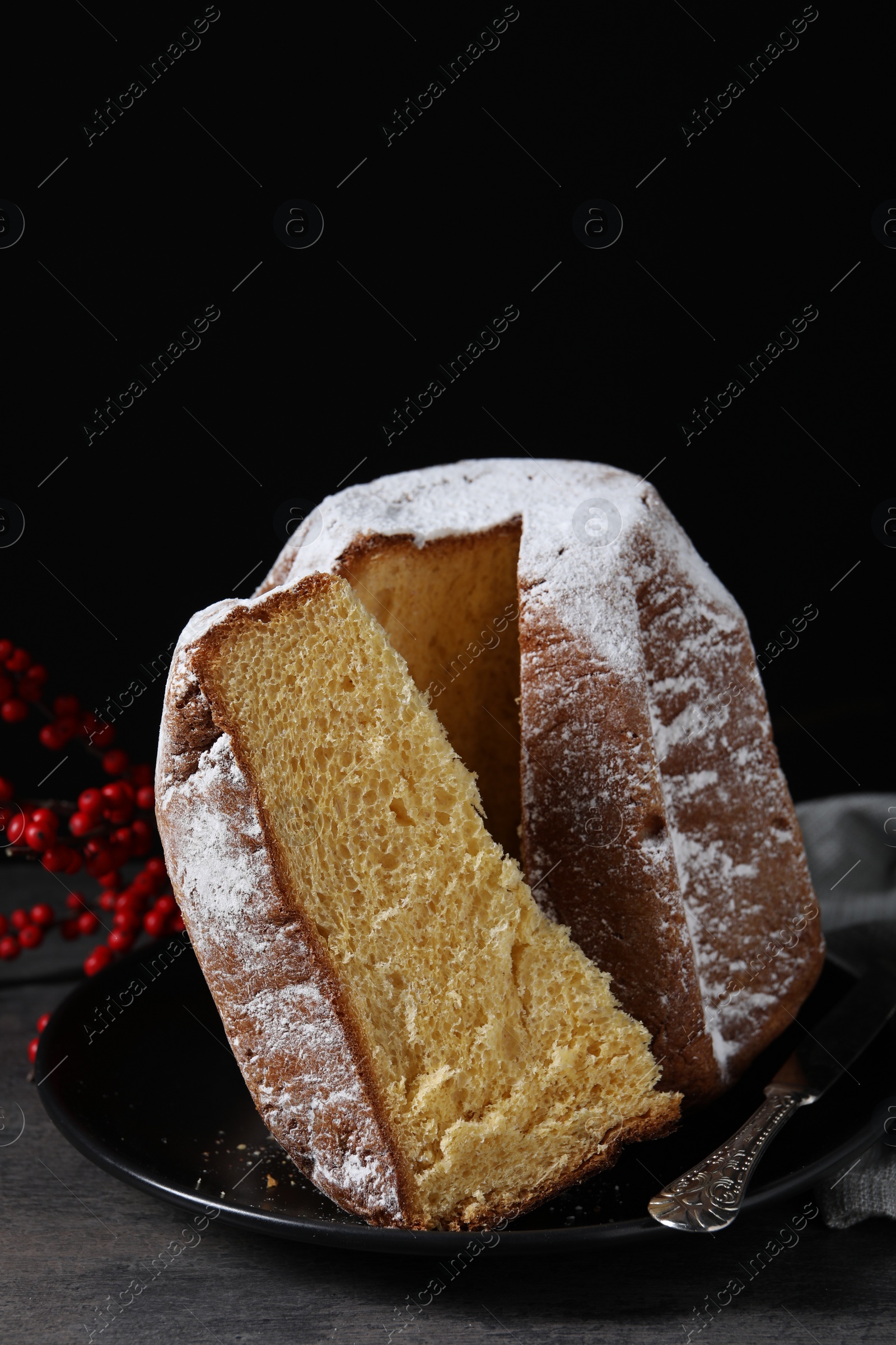 Photo of Delicious Pandoro cake with powdered sugar and decor on grey table. Traditional Italian pastry