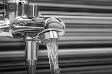 Image of Water flowing from tap in bathroom, closeup