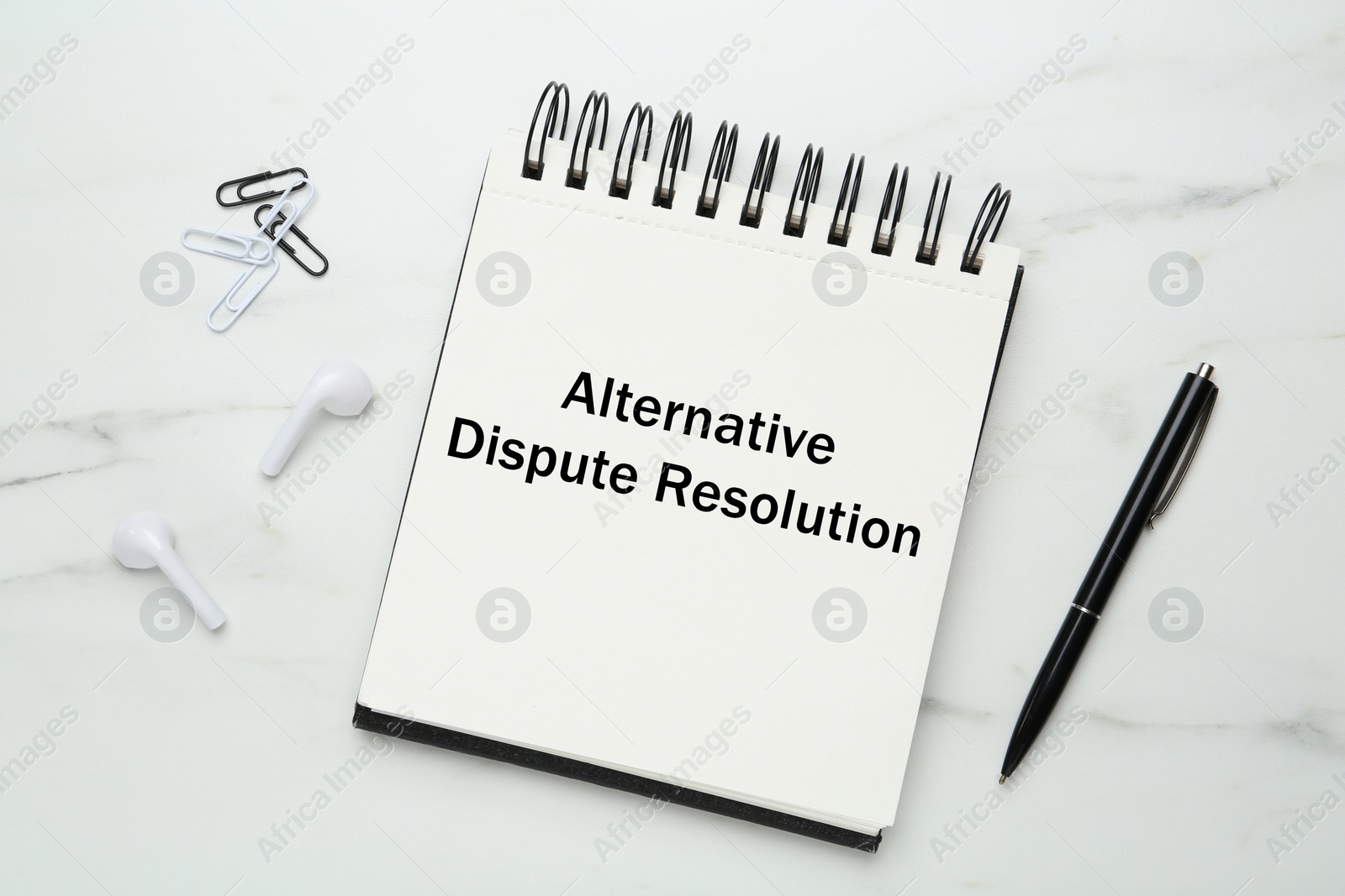 Image of Notebook with inscription Alternative Dispute Resolution and stationery on white marble table, flat lay