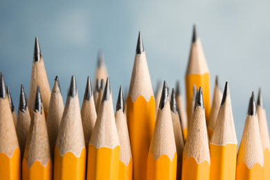 Photo of Many graphite pencils on blue background, closeup
