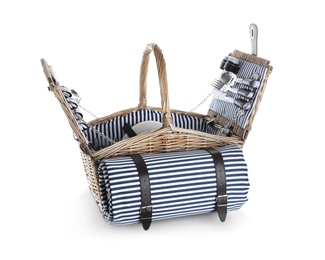 Photo of Wicker basket with picnic essentials and blanket on white background