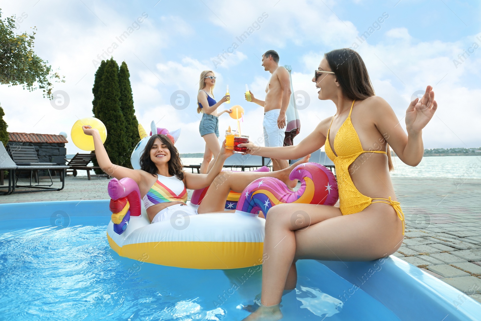 Photo of Group of happy people with refreshing drinks enjoying fun pool party