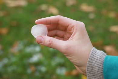 Photo of Woman holding hail grain after thunderstorm outdoors, closeup