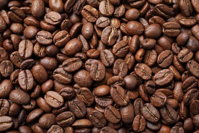Photo of Pile of roasted coffee beans as background, top view
