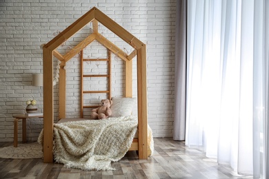 Photo of Stylish child room interior with cute wooden bed