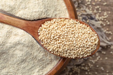 Wooden spoon with seeds on quinoa flour in bowl, top view