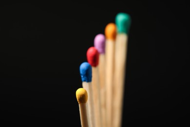 Photo of Matches with colorful heads on black background, closeup